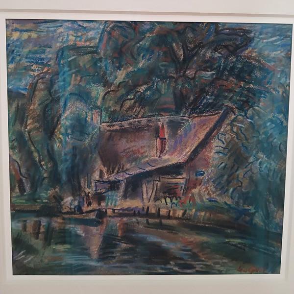 [Cottage on a wooded shore with a boat tied up nearby]